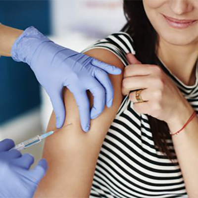 تصویری از بازوی یک زن که دکتر دارد به آن تزریق میکند